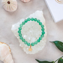 Ladda upp bild till gallerivisning, Elegant and stylish elastic Green Aventurine bracelet with details in 18k gold-plated 925 Sterling Silver and brass. Presented on a crystal cluster on a beach.
