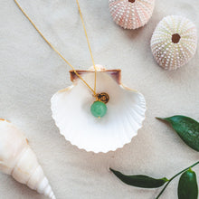 Ladda upp bild till gallerivisning, Unique and minimalistic 80 cm long Green Aventurine necklace with a faceted gemstone. Green Aventurine invites happiness and abundance into your life. Details in 18k goldplated sterling silver. Presented in a shell on a beach.
