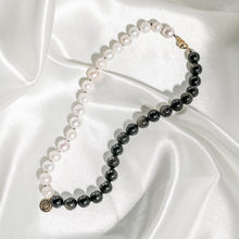 Load image into Gallery viewer, Choker pearl collier necklace presented on white silk. Handknotted pearl collier necklace with half in pearls and the other half in shimmering gold sheen obsidian gemstones. Details in 18k gold plated sterling silver.
