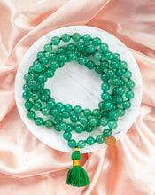Load image into Gallery viewer, Elegant and exclusive mala necklace with Green Aventurine crystals and details in 18k gold-plated 925 sterling silver and brass. Presented on marble and pink silk.
