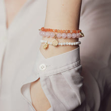 Load image into Gallery viewer, Business woman wearing Rose Quartz bracelet with details in 18k gold-plated 925 Sterling silver and brass. Rose quartz is called the love stone because it emits strong vibrations of love and happiness.
